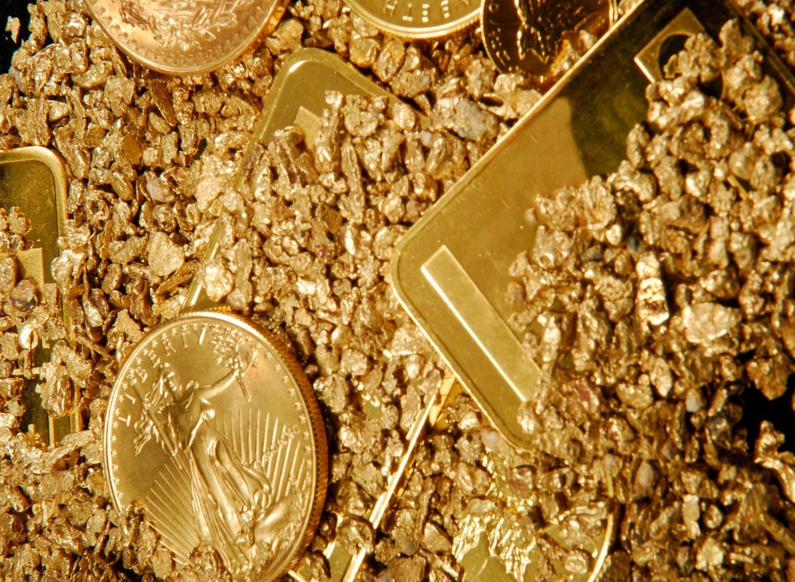 Золотые слитки и монеты в золотой россыпи