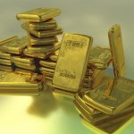 Цена на золото: риски нового снижения Золото в слитках на бирюзовом фоне