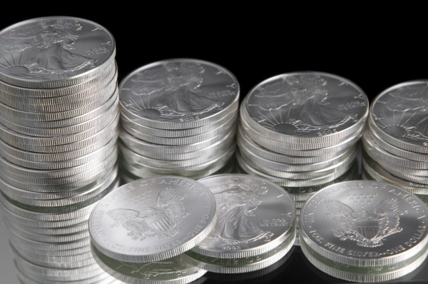 Стопки серебряных монет на чёрном фоне