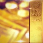 Слиток золота на фоне мутного изображения купюр долларов США