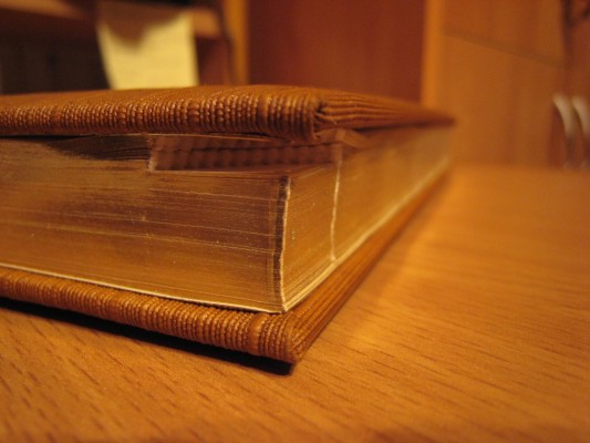 Книга с золотыми страницами на столе в закрытом виде