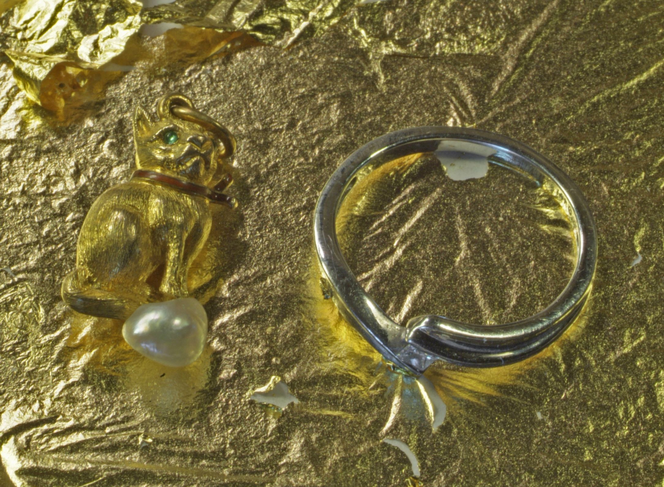 Серебряное кольцо на фоне золота
